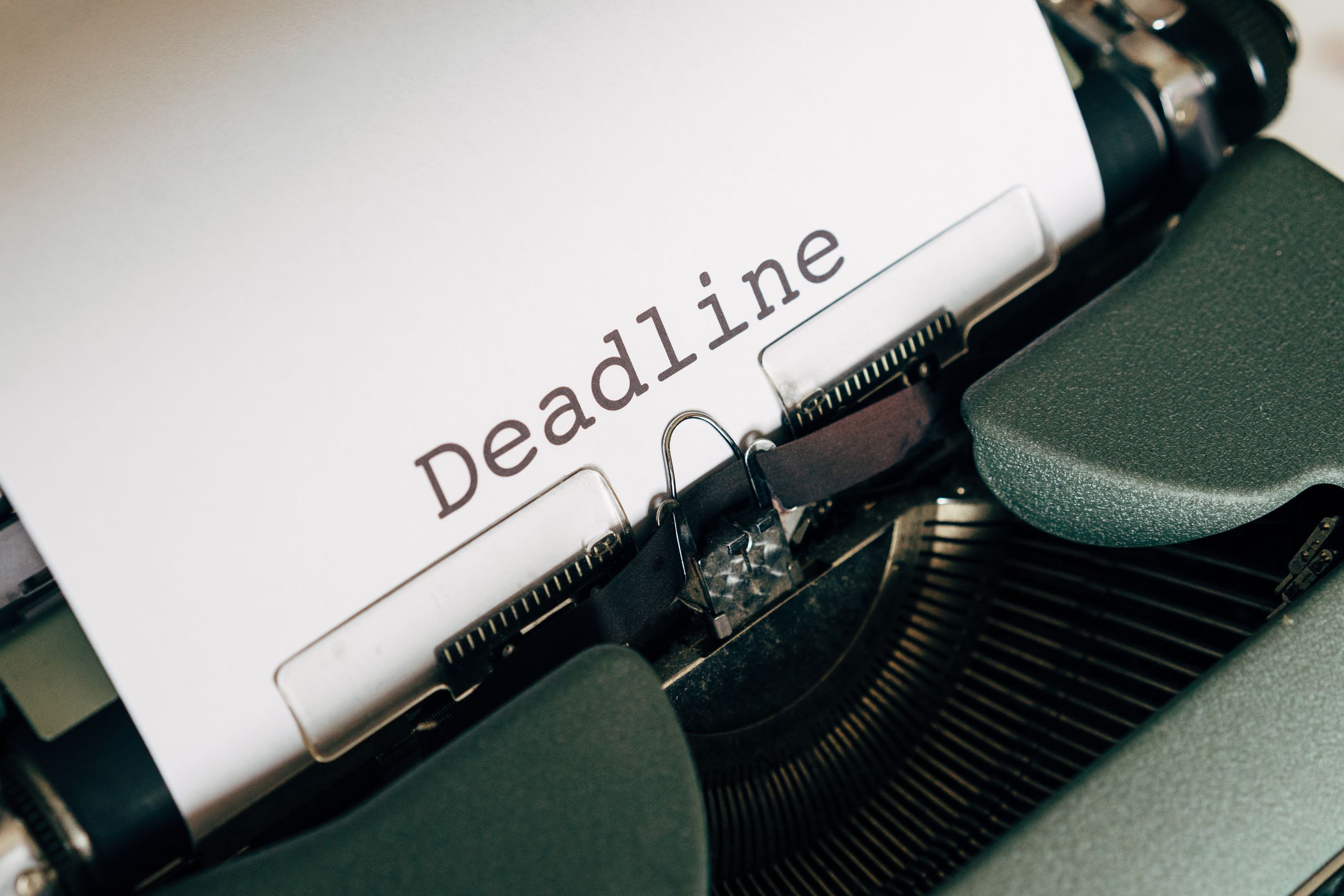 Close-up of a vintage typewriter with the word 'Deadline' on paper.