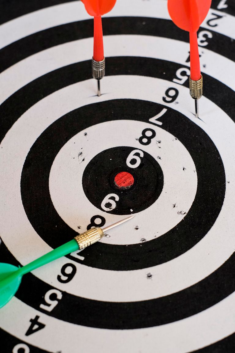 Close-up shot of darts hitting a dartboard target, showcasing precision and accuracy.