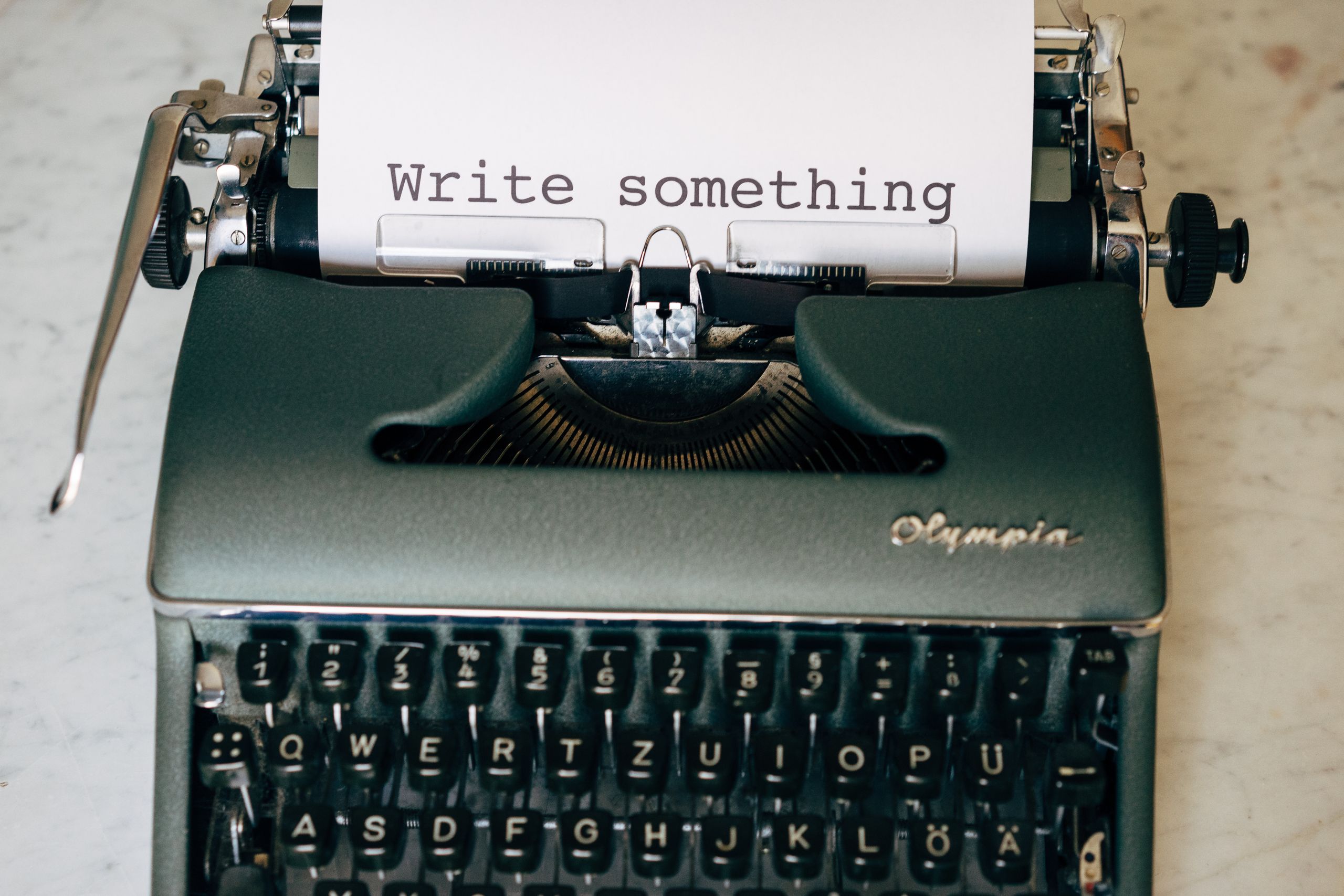 Classic typewriter displaying 'Write something' on paper. Perfect for creative inspiration.