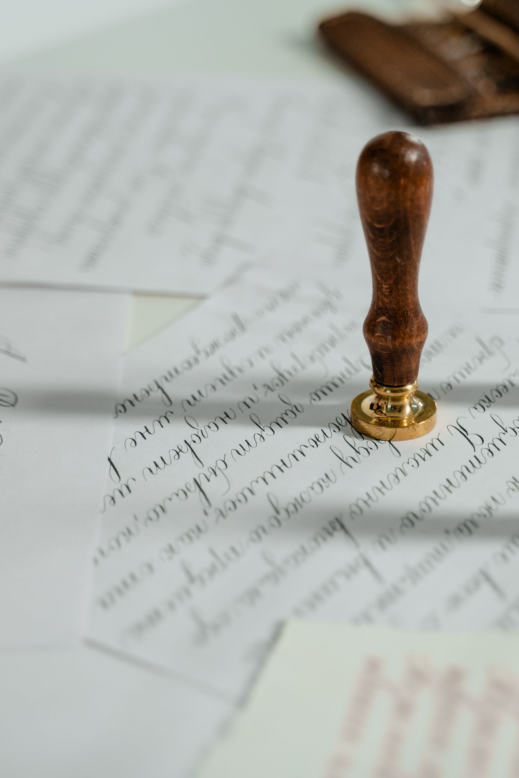 Vintage calligraphy papers with a wooden wax seal stamp, embodying timeless elegance.